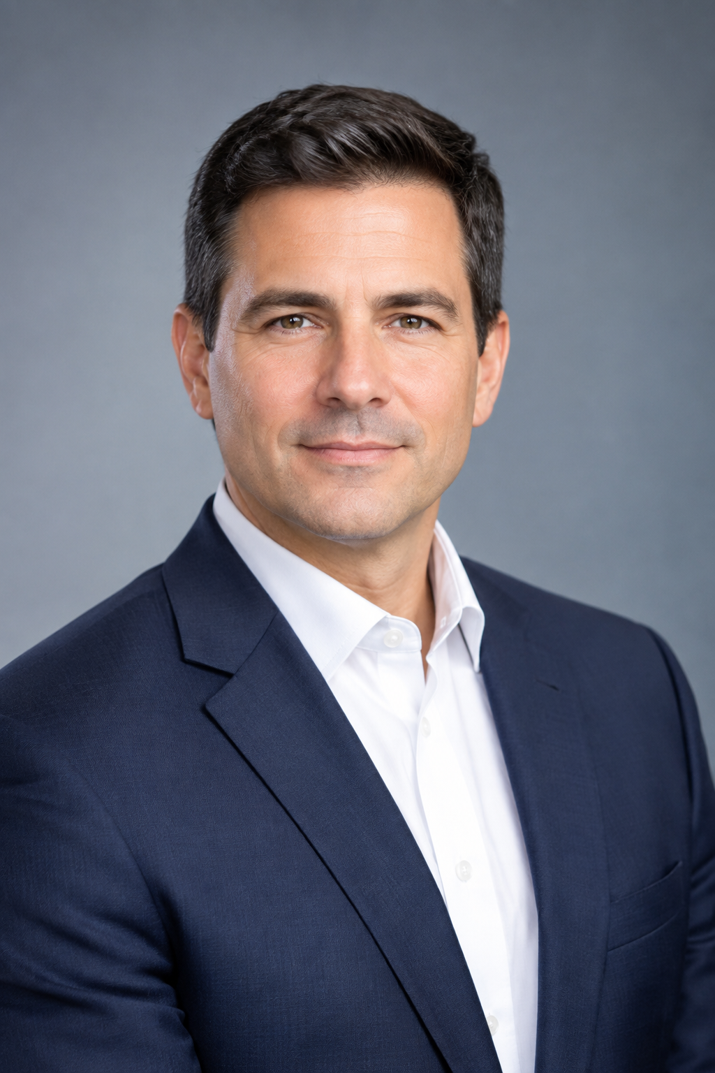 Founder and lead consultant in a navy suit, confident professional head-and-shoulders portrait with neutral studio background