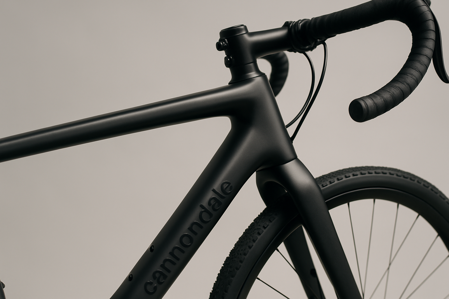 Close-up of a modern Cannondale Topstone carbon frame with matte black finish and subtle branding, showing the top tube and fork junction