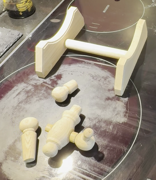 Early Crafthouz prototype wooden parts laid out on a dark work surface