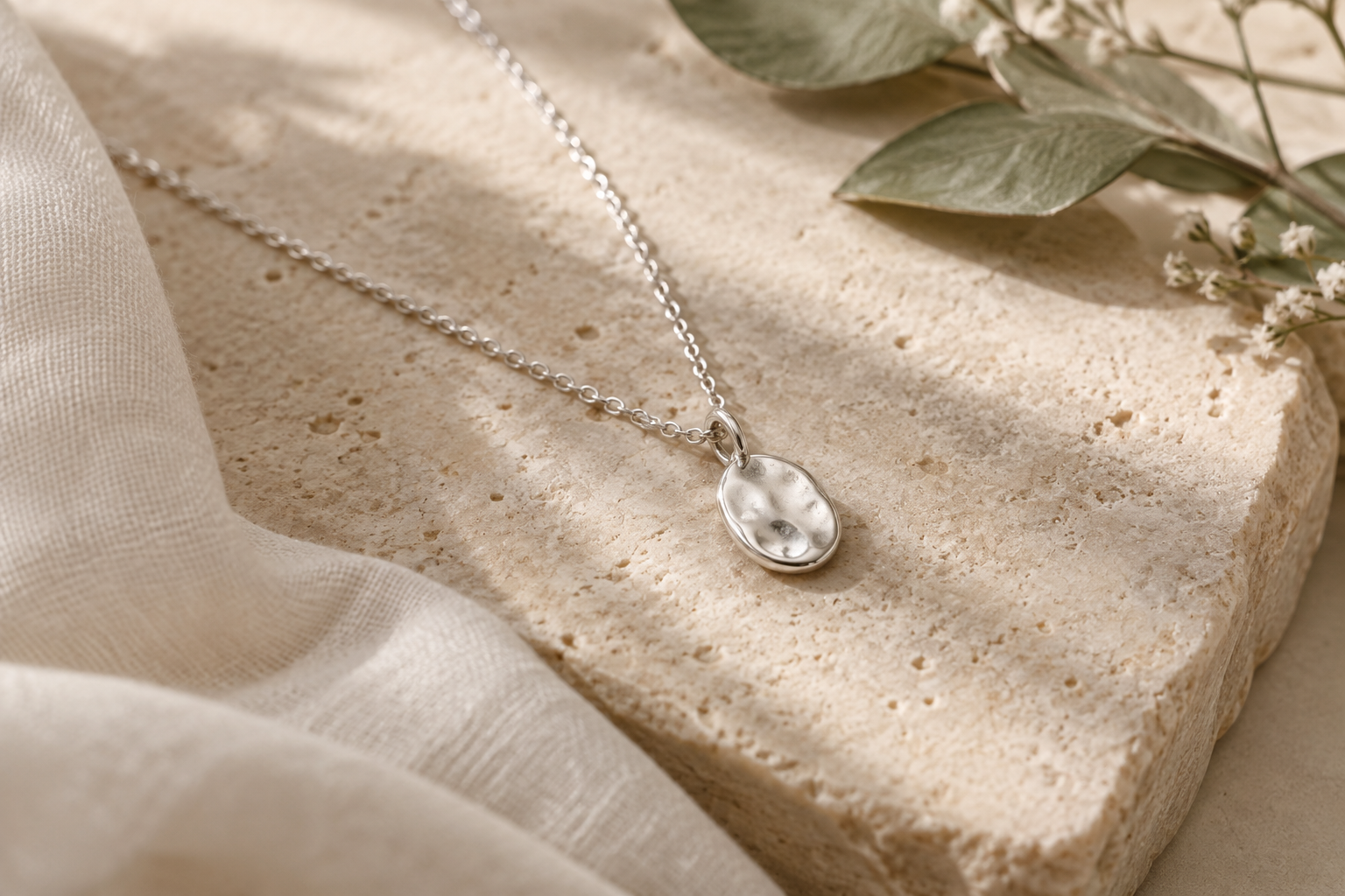 Delicate silver necklace close-up in warm natural light
