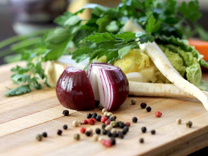 Red onion and peppercorns on a cutting board, representing a food business