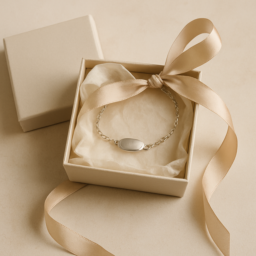 Premium jewelry gift box opened to reveal handmade piece wrapped in soft tissue paper and silk ribbon