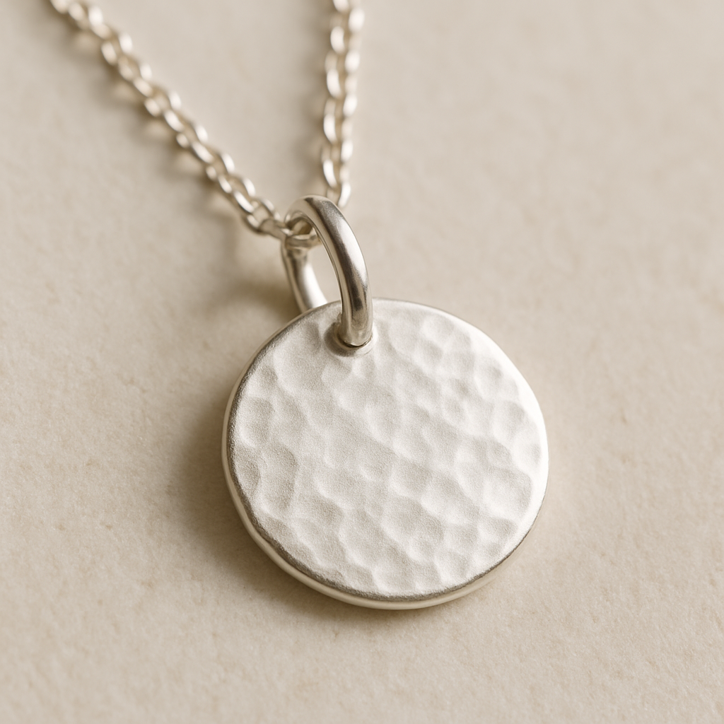 Textured silver disc pendant close-up