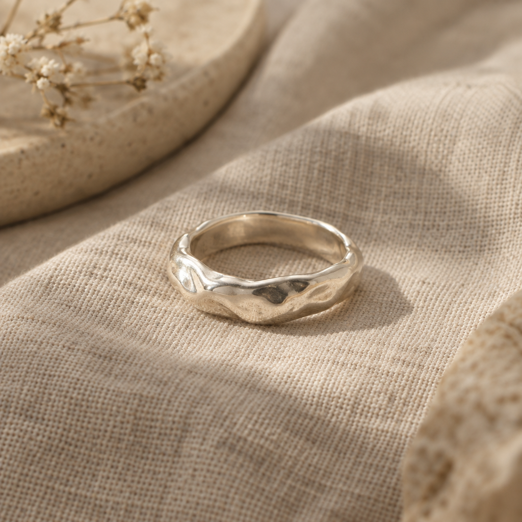 Handmade sculpted sterling silver ring on warm linen