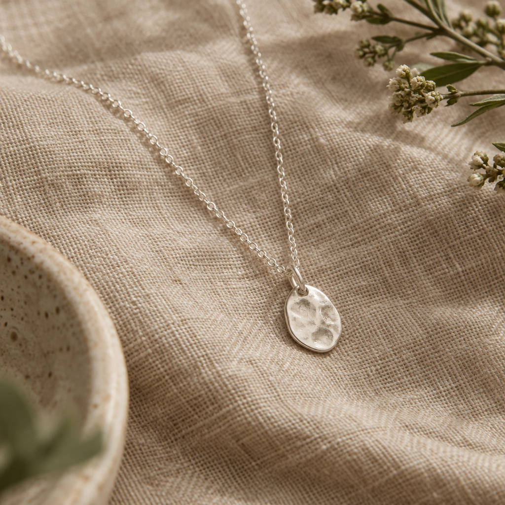 Fine silver pendant necklace on natural woven fabric