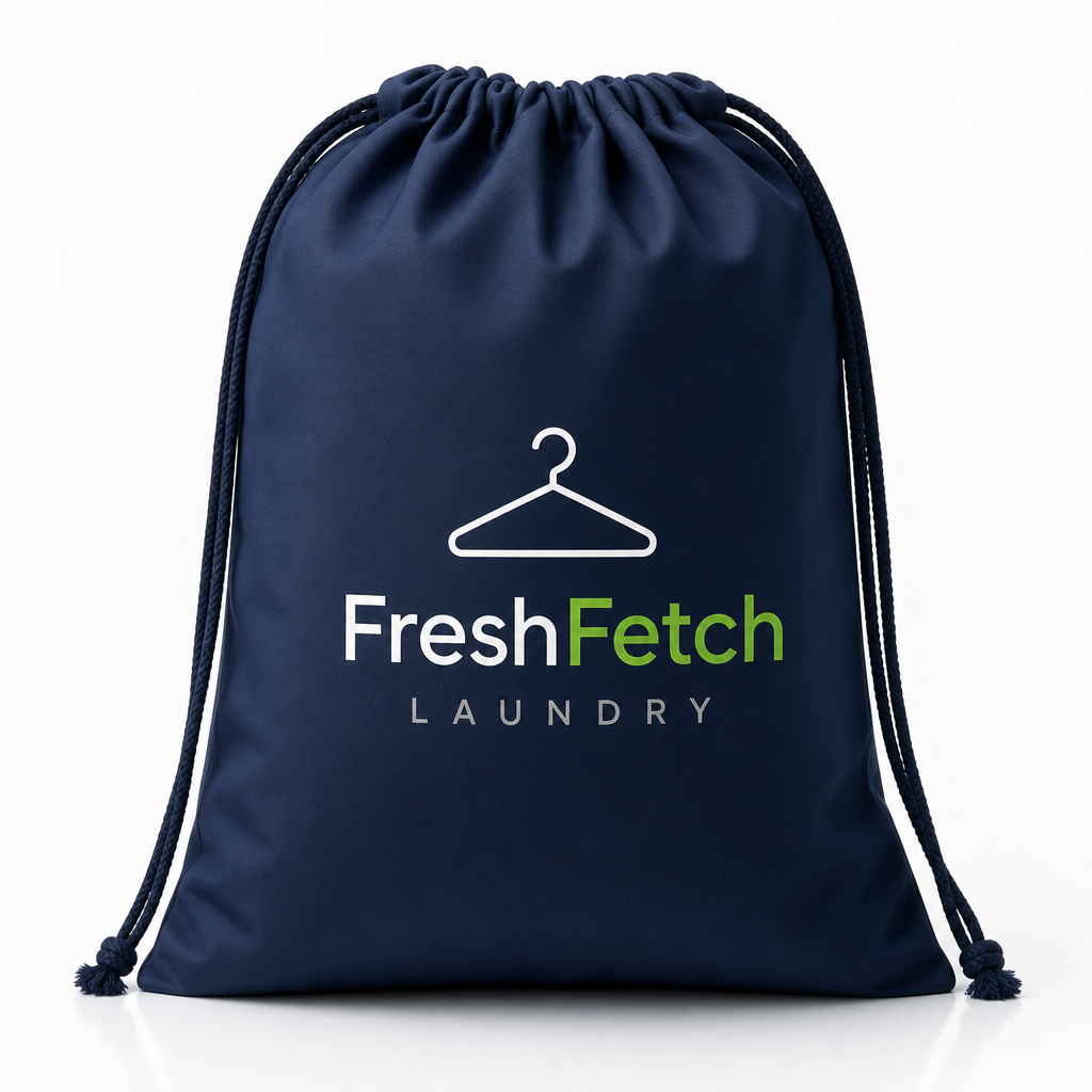 Premium medium FreshFetch laundry bag in soft white canvas with navy and green branding, neatly folded and presented