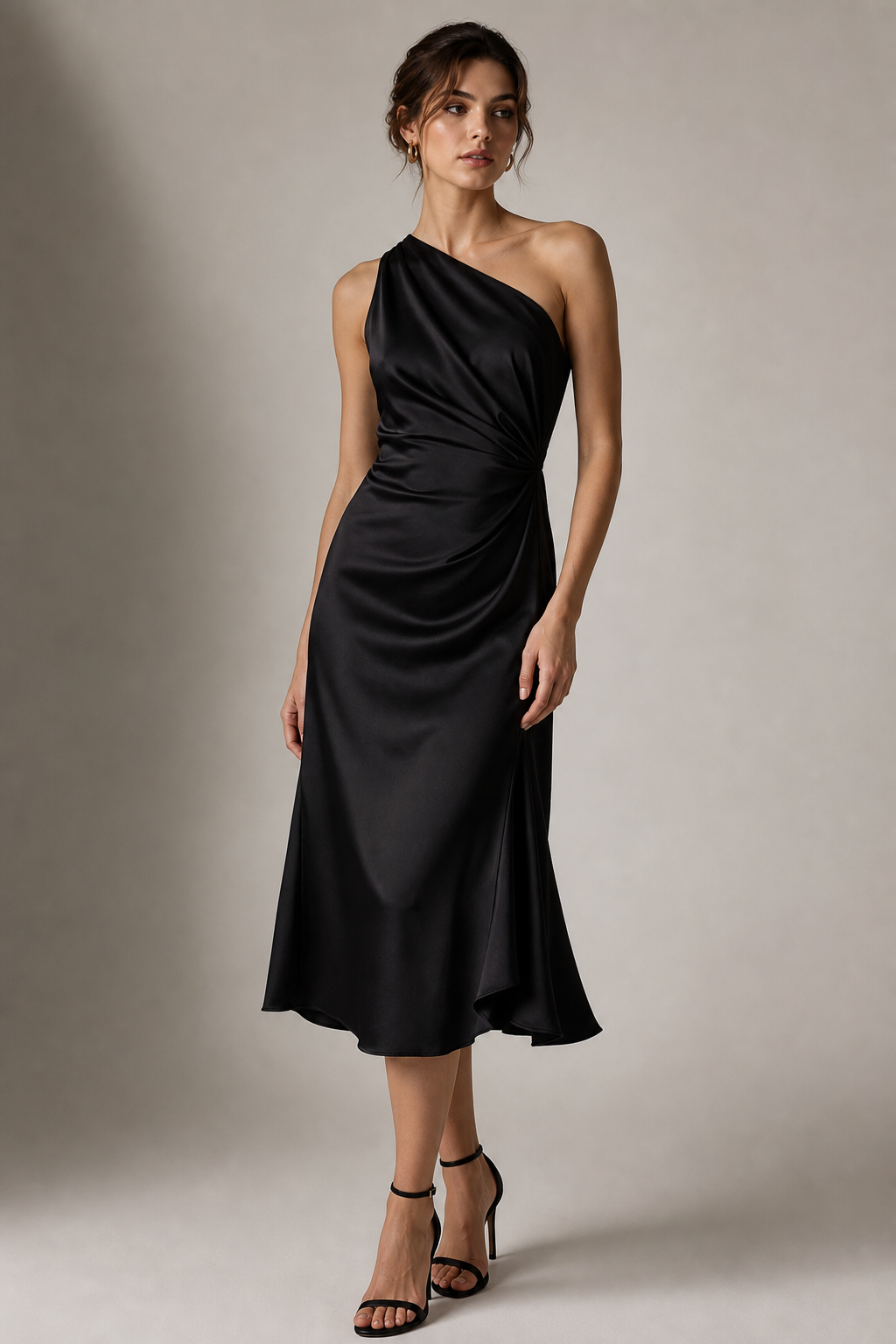 Model in a black silk midi dress with asymmetric neckline and soft drape