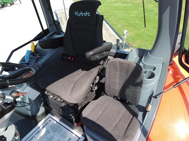 Kubota M7-132 Deluxe tractor rear view with implements attached, orange and green, crisp daylight, trustworthy and clear presentation