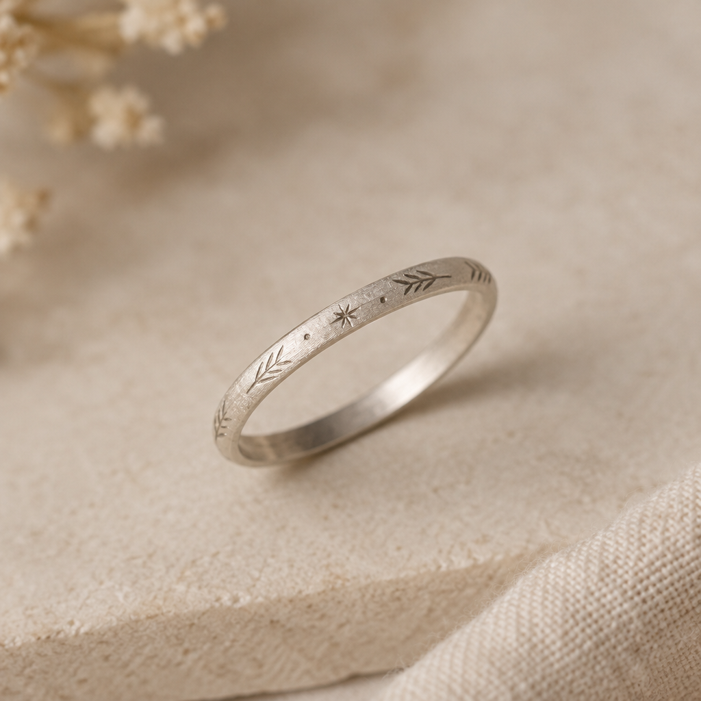 A slim matte sterling silver band with delicate hand-engraved marks
