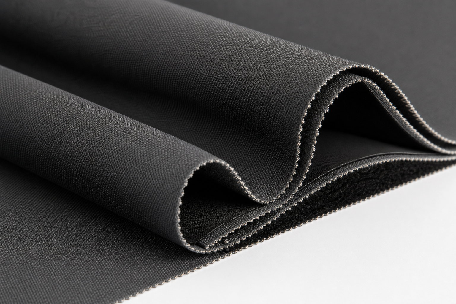 Close-up of deep charcoal triple-weave blackout curtain fabric with integrated black yarn core