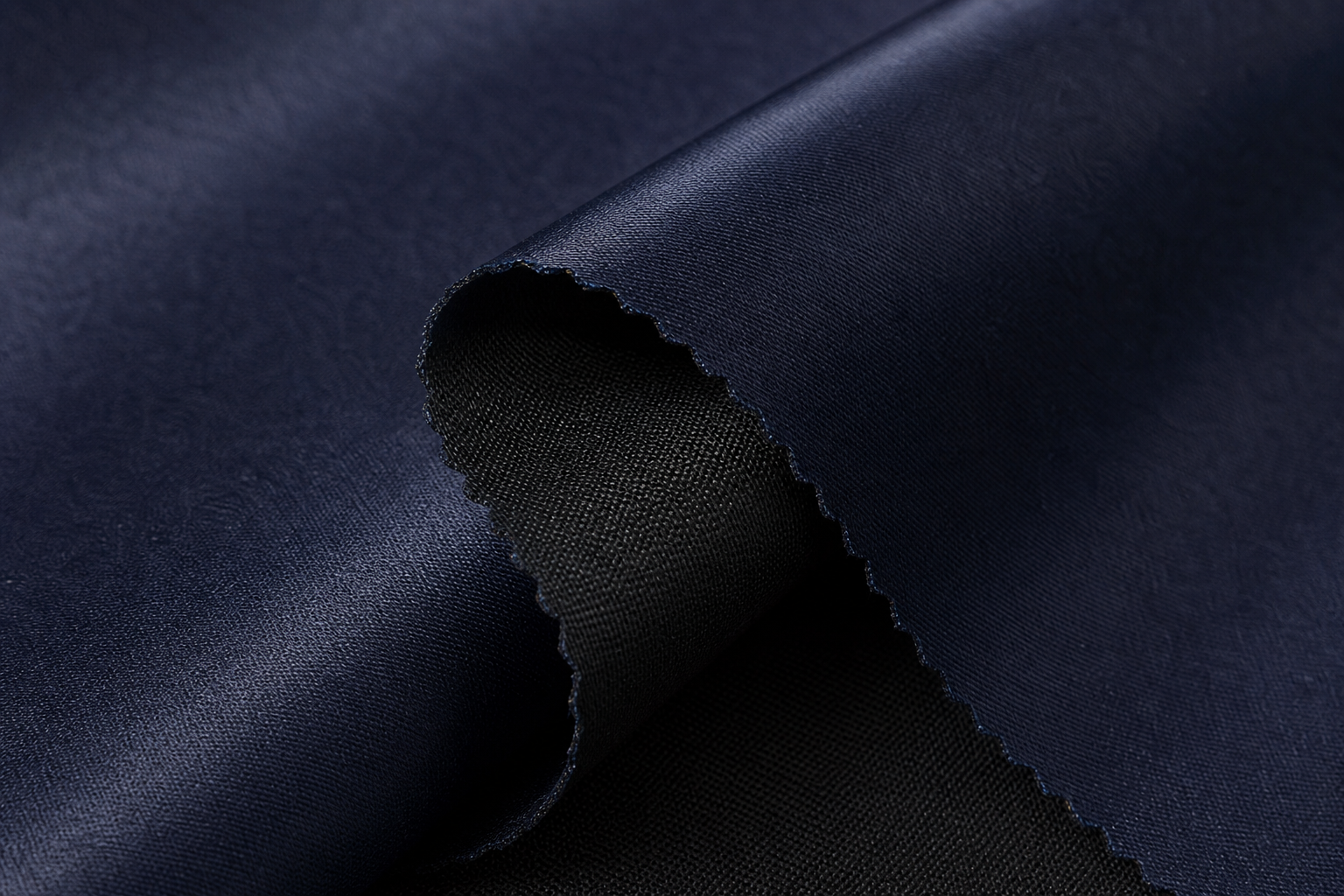 Detailed texture of midnight navy satin-face blackout drapery woven with black weft yarn