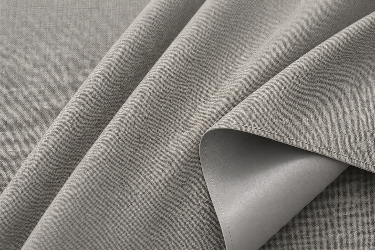Macro photograph of soft dove gray coated blackout drapery fabric with refined linen-like face texture