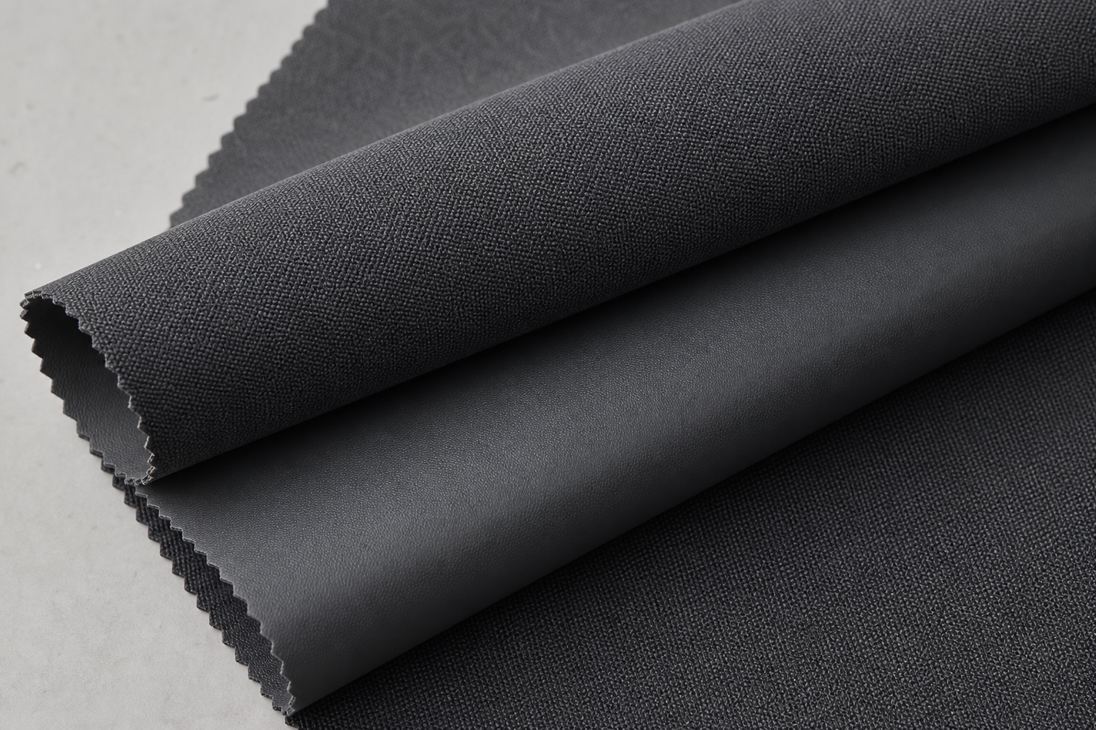 Permanent flame retardant dimout and blackout curtain fabric in deep charcoal with a smooth technical backing