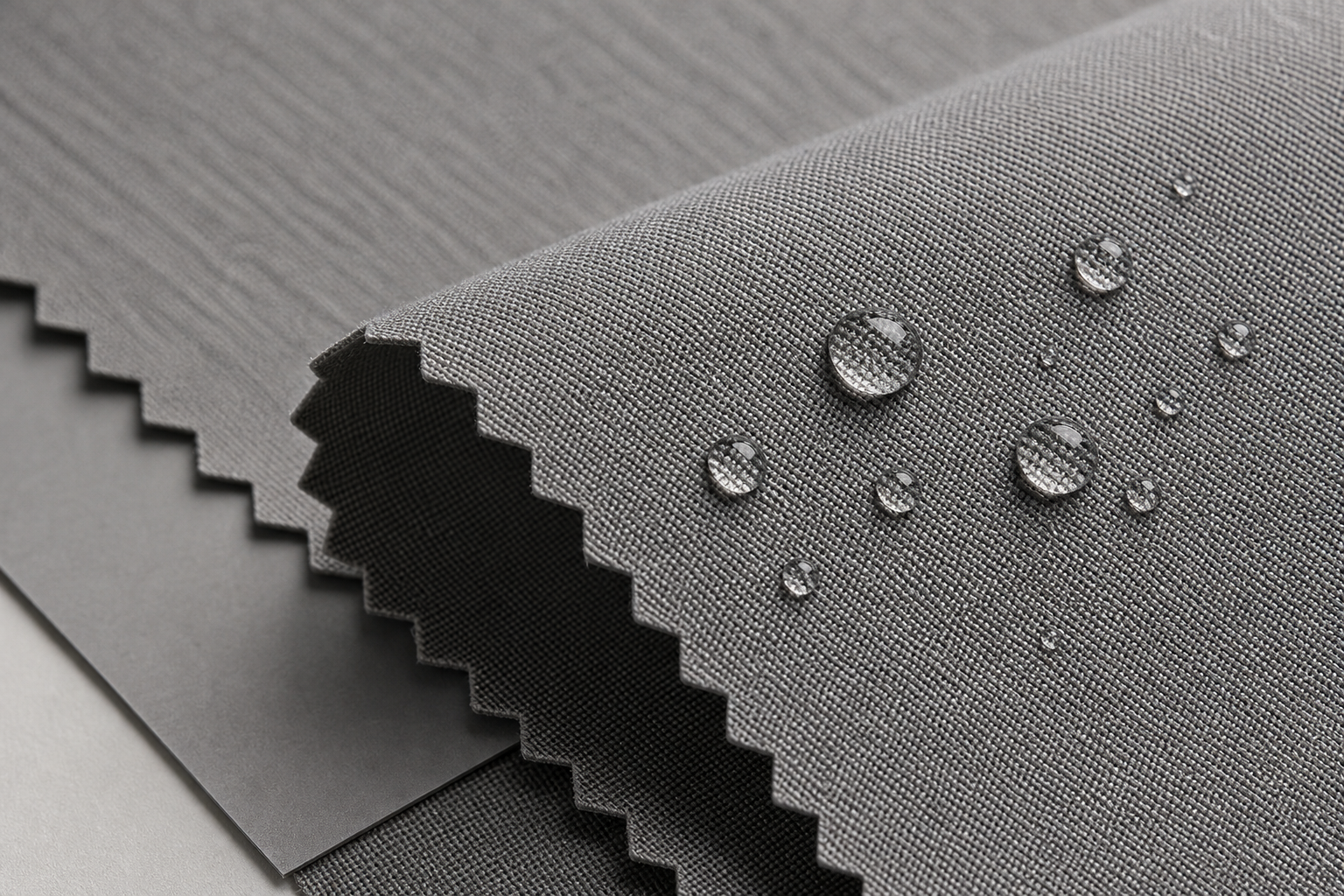 Close-up of light graphite three-proof curtain fabric with matte technical weave and clean easy-care finish