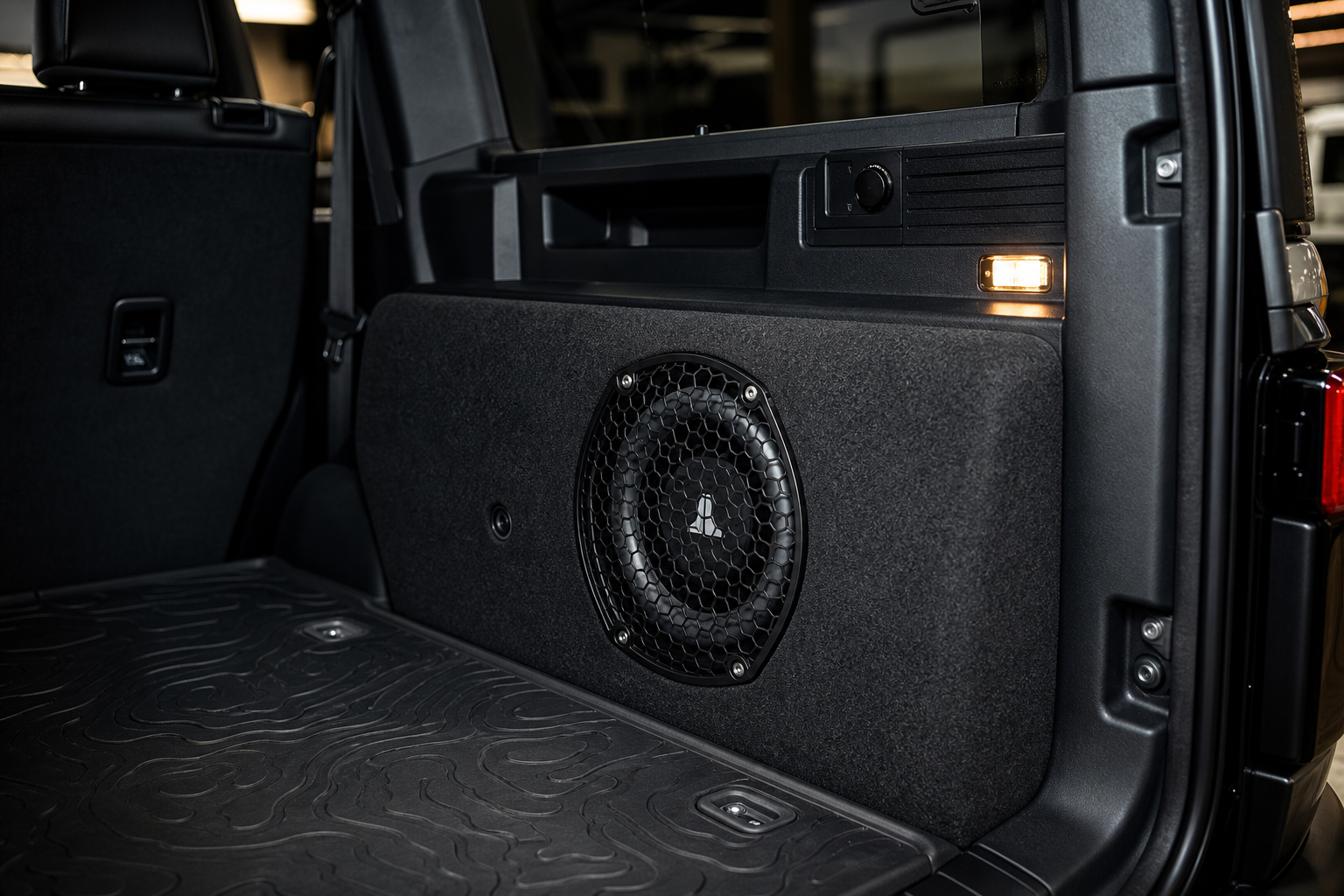 Custom rear cargo subwoofer enclosure contoured to interior trim