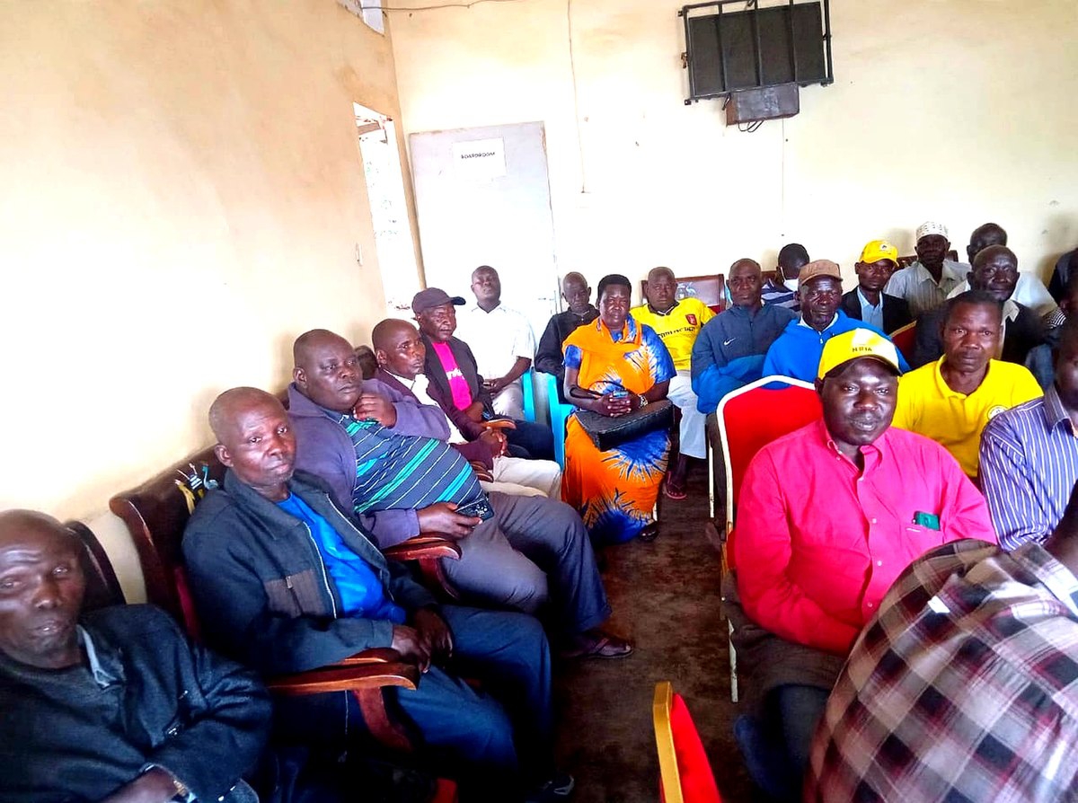 Parents and caregivers seated during a MAMA AND BABA CLUB community dialogue session in Zombo District