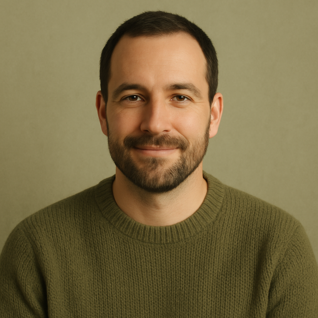 Portrait of Marcus T., a man with short dark hair and a trimmed beard wearing an olive sweater