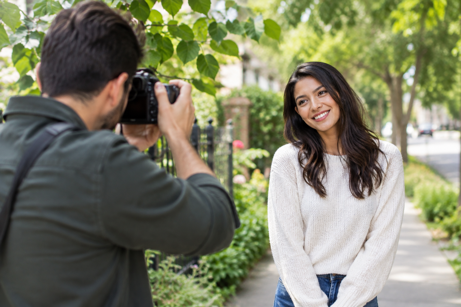 Photographer taking a casual outdoor portrait near a leafy neighborhood walkway