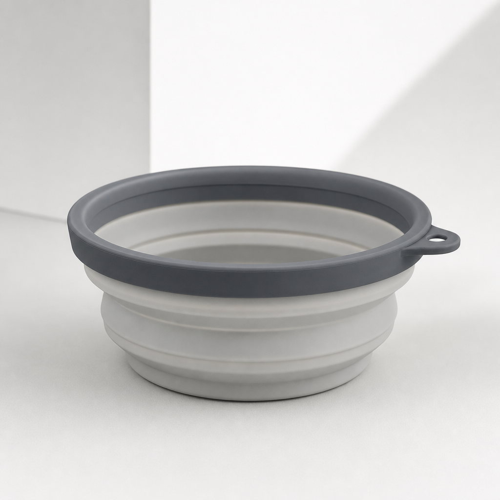 Collapsible silicone pet bowl with a slate-gray rim and soft matte finish, photographed on a clean studio surface