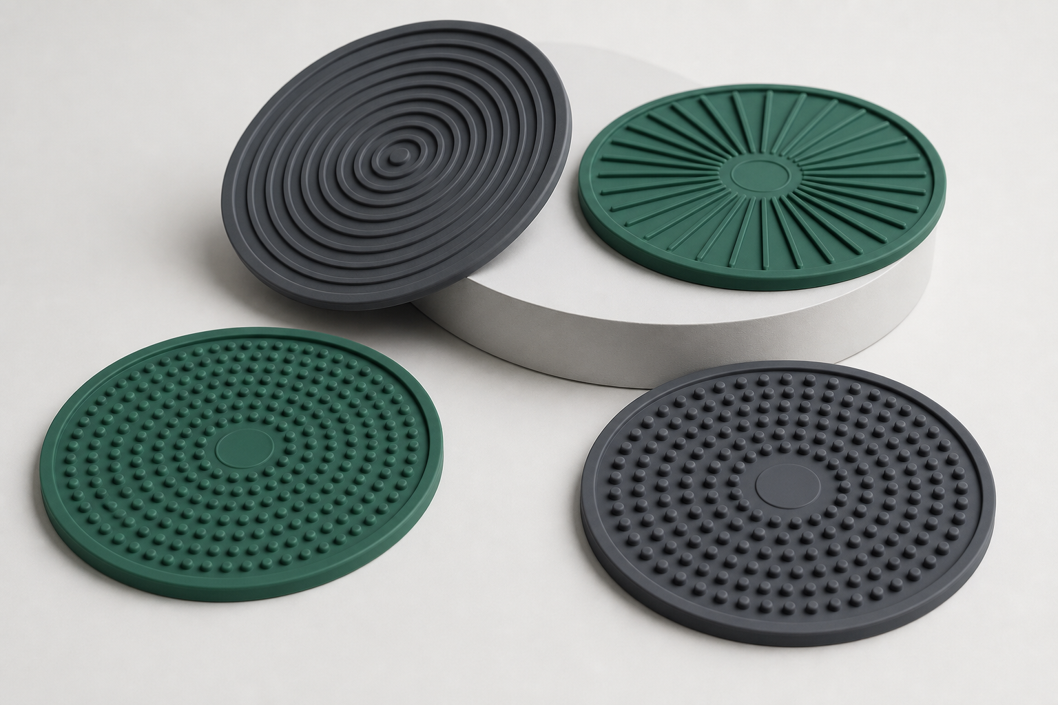 Studio-quality round silicone lick mats with concentric texture patterns in muted charcoal and deep green tones.