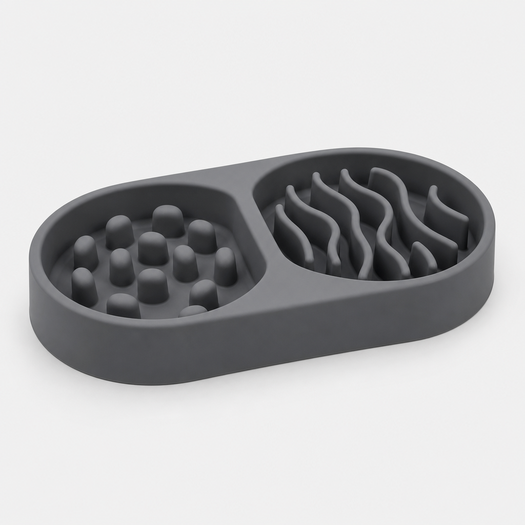 Double-compartment silicone slow feeder bowl in graphite gray with two textured feeding zones, photographed on a clean light gray background.