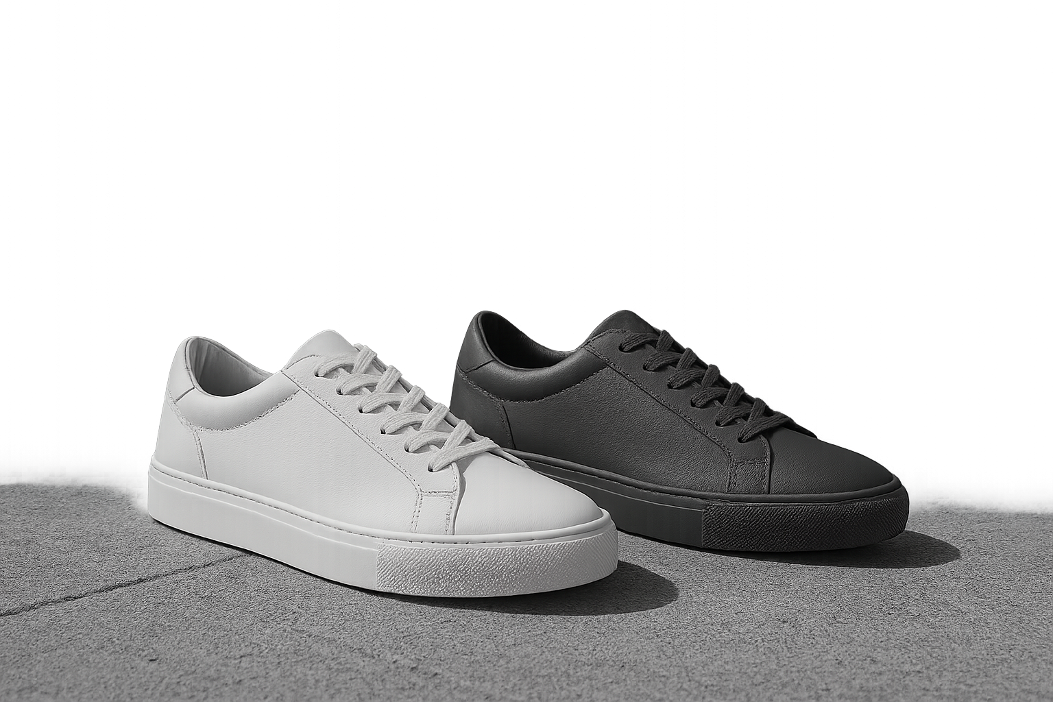 Low-top leather sneakers in white and graphite styled on a concrete rooftop