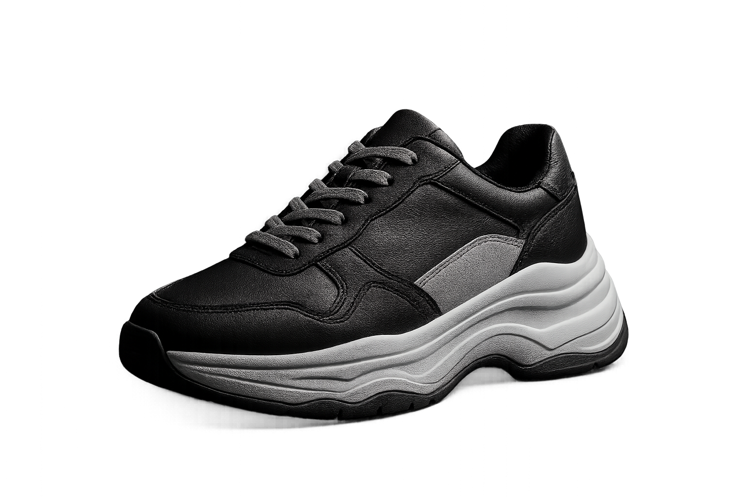 Chunky monochrome court sneaker with layered sole shot in a studio with hard shadows