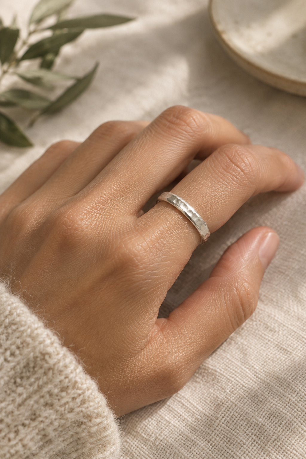 Close-up of a hand wearing a softly polished handmade silver ring