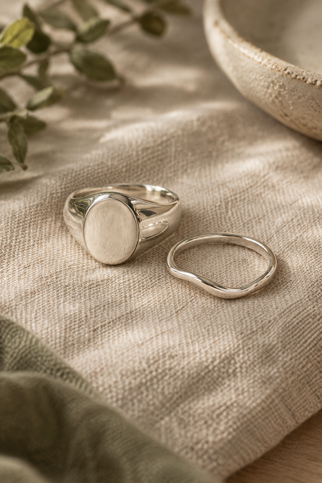 Polished sterling silver signet ring on warm linen