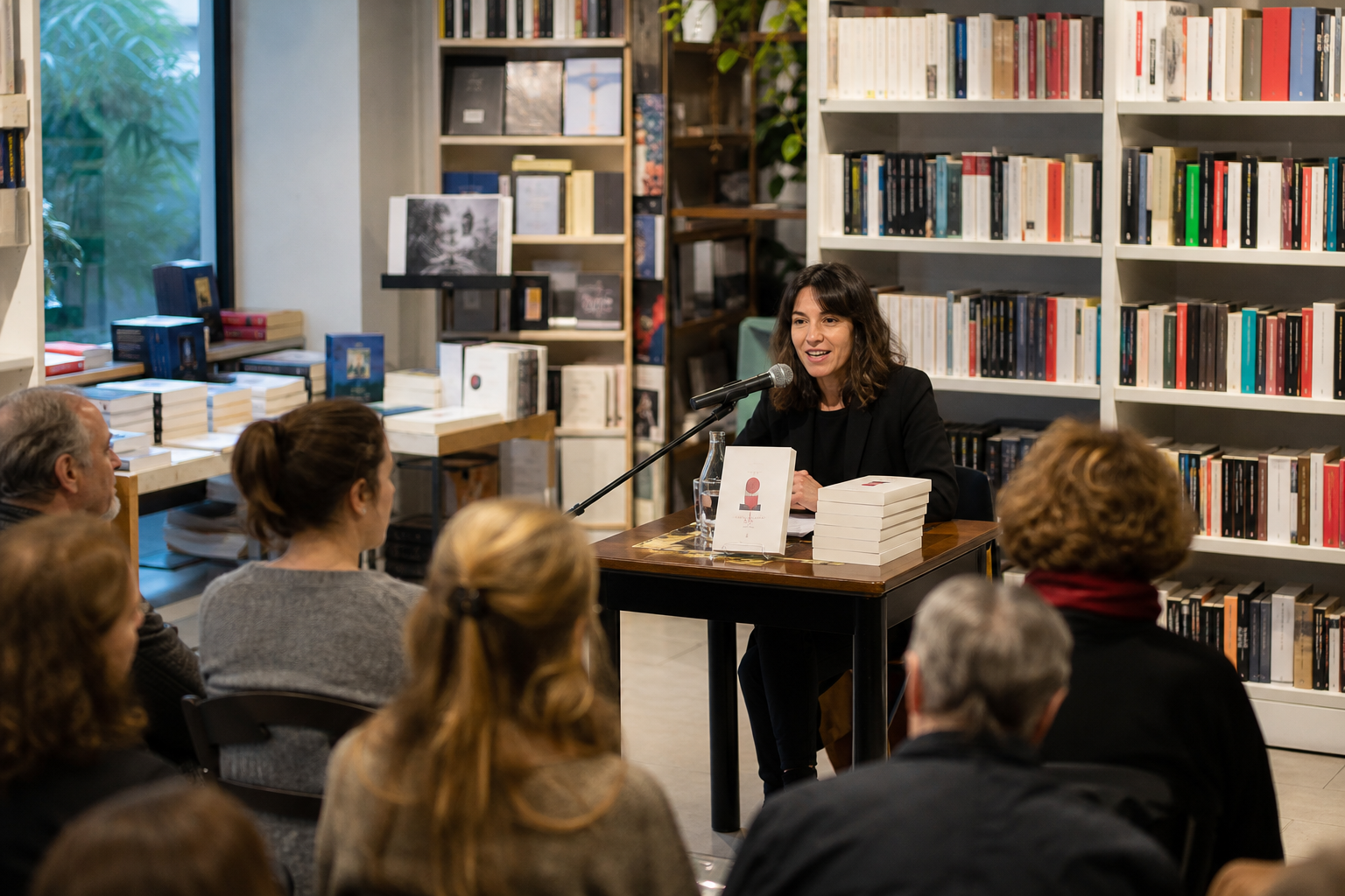 Presentazione di un libro in libreria con autrice al tavolo e pubblico